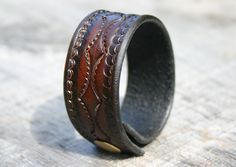 "Here is a leather bracelet that is tan with black faded edges.  This unisex leather wrist cuff features a custom tooled design and will be custom made for your wrist. It is just over 1\" wide and is held on with a matching brass snap! Each bracelet is custom made for each order.  So please be sure to select your personal wrist size, and I will make sure the bracelet fits you as you wish. The leather is an excellent durable vegetable tanned leather, that is approx 1/8\" thick. If you have any qu Adjustable Vintage Cuff Bracelet With Wrist Strap, Rustic Adjustable Cuff Bracelet, Adjustable Stamped Leather Cuff Bracelet, Vintage Adjustable Cuff Wristband, Brown Stamped Cuff Bracelets, Vintage Adjustable Cuff Bracelet In Distressed Brown, Rugged Adjustable Cuff Leather Bracelet, Adjustable Hand Tooled Cuff Bracelet, Brown Stamped Cuff Bracelet