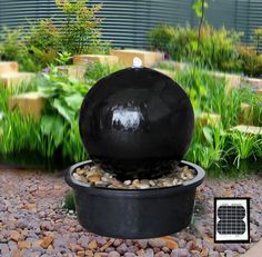 an outdoor fountain with rocks and gravel around it