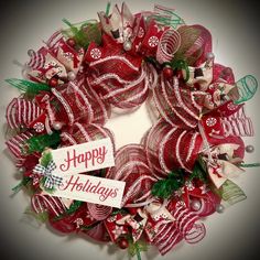 a red and white christmas wreath with happy holidays written on it