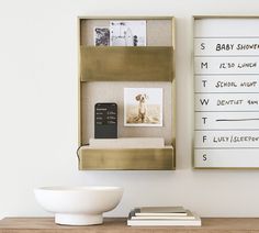 a white bowl sitting on top of a wooden table next to a wall mounted calendar