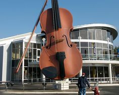 a giant violin sculpture in front of a building