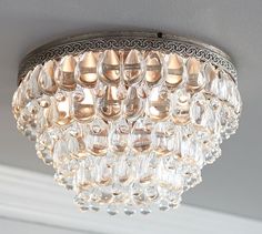 a crystal chandelier hanging from the ceiling in a room with gray walls and white trim