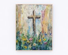 a painting of a cross in the middle of some grass and flowers on a white wall