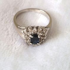 a close up of a ring with a blue stone in it on a white surface