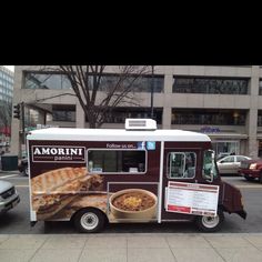 the food truck is parked on the side of the street