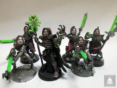 a group of miniature figurines with green and black paint