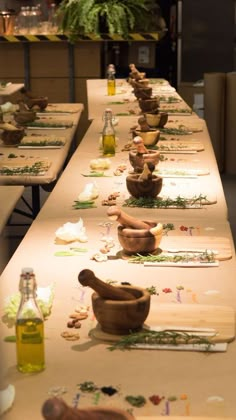 a long table with several wooden bowls and spoons lined up on top of it