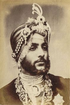 an old black and white photo of a man wearing a turban with beads on his head