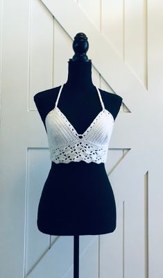 a mannequin wearing a white crochet halter top on a dummy