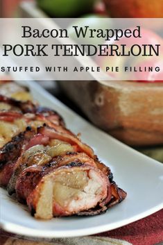 bacon wrapped pork tenderloin on a white plate with apples and limes in the background