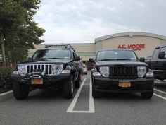 two black jeeps parked in front of a store