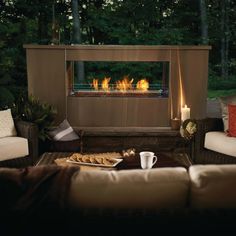 a living room filled with furniture and a fire place in the middle of it's fireplace