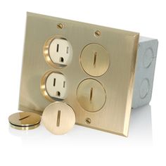 an electrical outlet with three outlets and two plates on the wall, all in gold