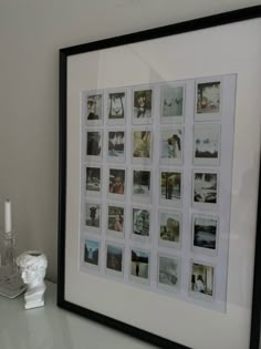 a white table topped with a framed photo next to a candle holder and vase filled with flowers