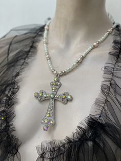 Large filigree cross pendant pearl chain. Cross has iridescent rhinestone. I have used two colour pears for the chain. Light cream rose 10 mm glass pearls and ivory 6 mm glass pearls. Cross is zinc alloy. I can do any colour pearls to suit you. Silver Pearl Rhinestone Necklace For Gift, White Cross-shaped Jewelry With Rhinestones, White Cross-shaped Rhinestone Jewelry, Silver Cross Jewelry With Beads, White Rhinestone Cross Jewelry, White Cross Necklace With Rhinestones, Spiritual Cross Necklace With Pearl Charm, Silver Pearl Cross Pendant Necklace, Cross Pendant Necklace With Pearl Charm