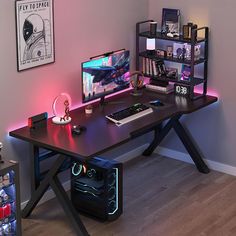 a desk with a computer on it in front of a book shelf and other items