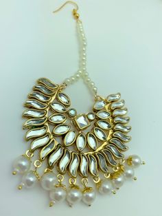 a necklace with pearls and gold accents on a white surface, close up view from the front