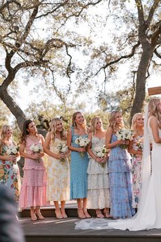 a group of women standing next to each other in front of a wedding ceremony arch