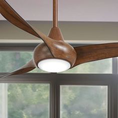 a wooden ceiling fan in front of a window