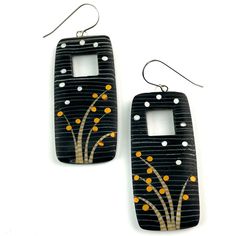 two black and white earrings with yellow dots on them, one has a tree in the middle