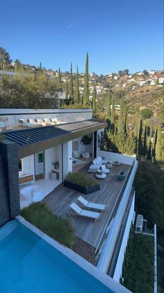 a house with a swimming pool in front of it and lots of greenery on the roof