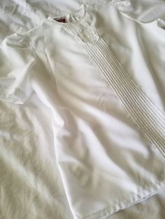 "Vintage white blouse. Made by Jonquil by Judy Bond. Crew neck. Pleated front with lace applique. Short sleeves. Button closure at nape. Boxy. 80s. 100% polyester. (measurements taken flat) Label size: 10 Bust: 21\" Waist: 20.5\" Length: 25.5\" Shoulder width: 15\" Sleeve length: 10.5\" Armscye: 10\" Excellent vintage condition. No rips, holes, or stains." White Fitted Blouse With Lace Sleeves, White Pintucks Top For Daywear, White Pintuck Top For Daywear, Summer White Blouse With Pintucks, Formal White Blouse With Lace Sleeves, Classic Short Sleeve Blouse With Lace Trim, Summer Fitted Shirt With Lace Collar, Classic White Tops With Pintucks, Fitted Shirt With Lace Collar For Summer