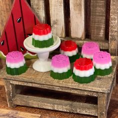 there are many desserts on the table with watermelon slices in them and one is sitting on a cake plate