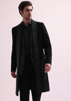 a man wearing a black coat and pants