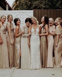 a group of women standing next to each other in long dresses and one woman wearing a dress