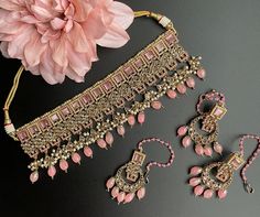 This is a beautiful Choker that comes with a set of earrings and maangtika. Can be worn on any outfit or for a bridal look as its a complete set. Comes in 2 colors - Pink and Beige Pink Indian Jewelry, Indian Jewelry Simple, Bridal Indian Jewelry, Bridal Indian, Jewelry Kundan, Beautiful Chokers, Kundan Jewelry, Polki Necklace, Bollywood Jewelry