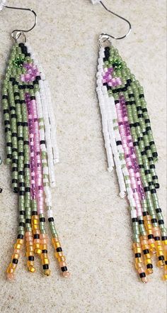 the beaded earrings are hanging from hooks on the floor, with beads attached to them