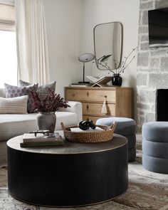 a living room filled with furniture and a fire place next to a window on top of a rug