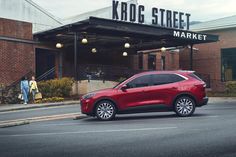 a red car parked in front of a market