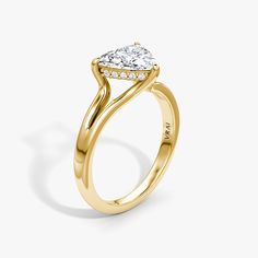 a yellow gold engagement ring with a pear shaped diamond in the center and side stones