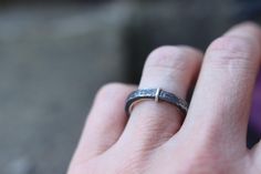 a close up of a person's hand with a wedding ring on their finger