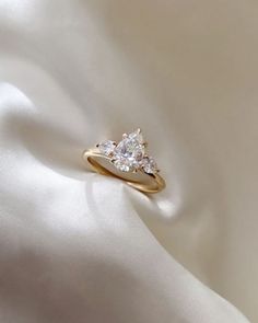 three stone diamond ring on white fabric