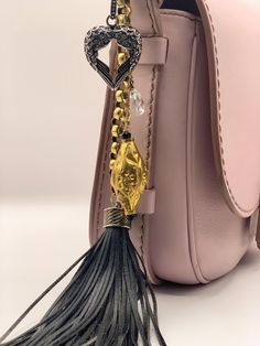 a pink handbag with a tassel hanging from it