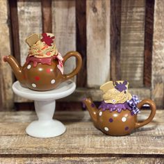 two ceramic teapots with hats on them