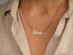 This bold name necklace is a gorgeous way to show off your personality. The flat figaro chain is 3.00 mm in width and composed of 14k solid gold. Mix up the font and chain length to create a unique look. FEATURES • Material: 14k Solid Gold (Stamped 14K for authenticity) • Color Options: Yellow Gold • Chain Style: Flat Figaro Chain • Chain Width: 3.00 mm • Clasp Type: Lobster Clasp • Width x Height: 35.00 mm x 14.65 mm • Available Lengths: 14", 15", 16", 17", 18", 19", 20" • Font Type: F12 For cu Gold Figaro Chain, Figaro Chains, Figaro Chain, Font Types, Yellow Gold Chain, Bold Style, The Font, Name Necklace, Chain Styles