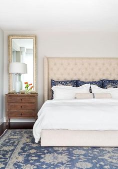 a bedroom with a large bed, dresser and mirror in it's center area