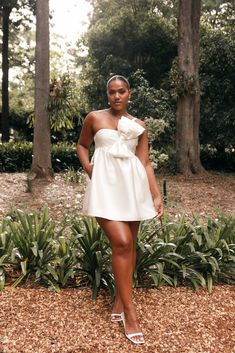 a woman in a white dress posing for the camera