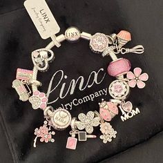 Linx Snake Chain Style Charm Bracelet With A Ball Clasp, Featuring Linx Logo. The Bracelet Comes With 15 Linx Charms As Shown. *All Items Are 925 Sterling Silver. *Linx Bracelets And Charms Are Very Well Made And Of Superior Quality, Designed To Last. These Pieces Come With A 100% Satisfaction Guarantee Or Your Money Back. *The Bracelet Is Available In Multiple Sizes *Additional Charms Can Also Be Added To The Bracelet And The Ones Included Are Removable As Well. *Linx Bracelets And Charms Are U Pink Stainless Steel Jewelry With Charms, Pink Stainless Steel Bracelet Jewelry, Pink Stainless Steel Bracelet, Pink Stainless Steel Jewelry, Pink Sterling Silver Jubilee Bracelet, Silver Chain Stainless Steel Charm Bracelet Gift, Stainless Steel Charm Bracelet With Silver Chain As Gift, Silver Sterling Silver Bracelets For Mother's Day, Silver Stainless Steel Chain Bracelet With Charms