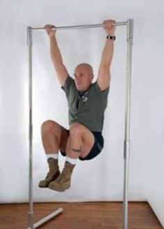 a man is hanging upside down on a metal frame with his feet in the air