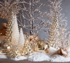 christmas decorations are displayed in front of snow covered trees and ornaments with bows on them