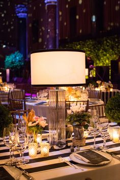 the table is set with candles, plates and silverware for an elegant dinner party