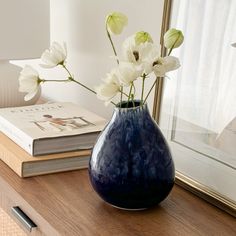 a vase filled with white flowers on top of a wooden table