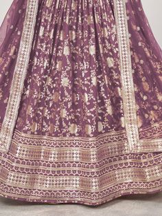 This purple jacquard lehenga ensemble, adorned with intricate zari embroidery and dazzling sequin work. The majestic hue of purple radiates sophistication and allure, making it an ideal choice for weddings, festivities, and special occasions. Crafted from luxurious jacquard fabric, the lehenga boasts a semi-stitched design, offering a comfortable fit of up to 42 inches while allowing freedom of movement.
Accompanying the lehenga is a matching jacquard choli, intricately embellished with zari emb Designer Purple Art Silk Sharara, Purple Meenakari Sets For Diwali, Purple Art Silk Sharara For Eid, Purple Art Silk Anarkali Set For Reception, Purple Meenakari Lehenga For Navratri, Purple Art Silk Sharara With Dupatta, Navratri Purple Brocade Traditional Wear, Purple Art Silk Sets With Resham Embroidery, Purple Brocade Traditional Wear For Navratri