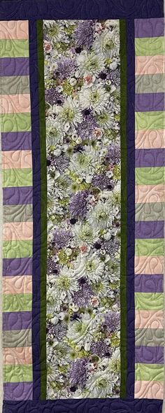 a quilted wall hanging with flowers on it