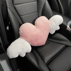 a pink and white heart shaped pillow in the back seat of a car