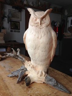 an owl statue sitting on top of a wooden table